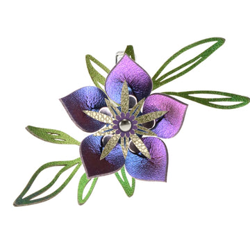 A custom designed vegan flower barrette featuring green leaves and a large iridescent blue flower.