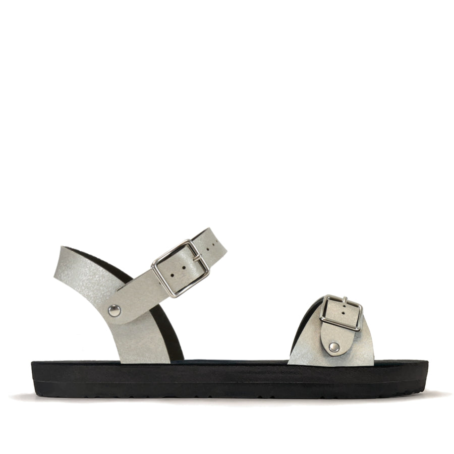 Side view of a flat, padded vegan sandal in champagne color with an ankle strap