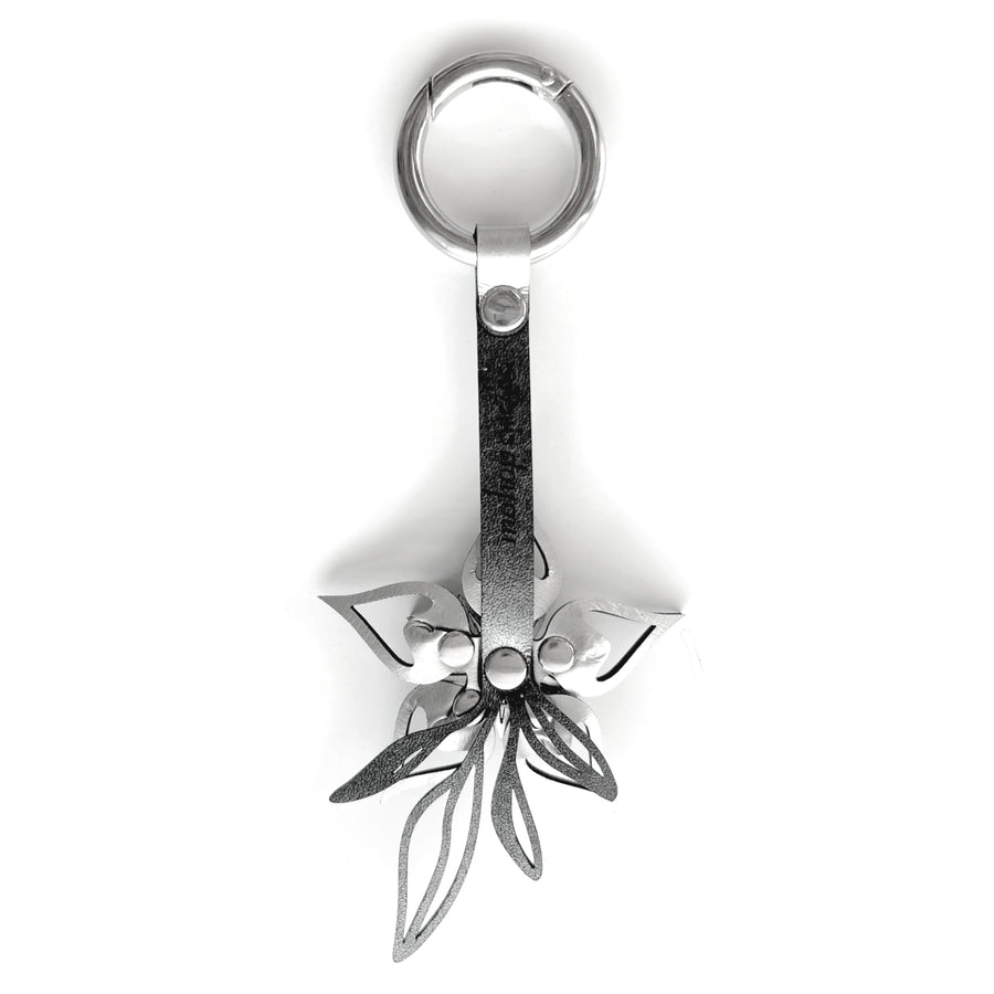 The silver back side of purse charm shown on a white background