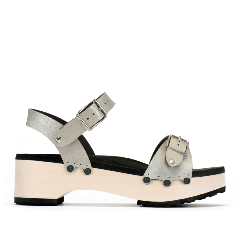 A side view of a flatform clog with a buckle toe and ankle, shown in matte black