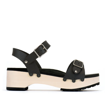 A side view of a flatform clog with a buckle toe and ankle, shown in matte black