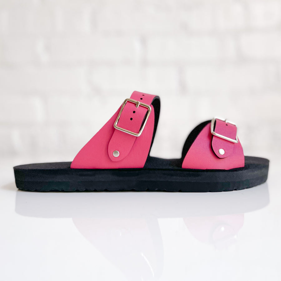 Side view of a flat, padded vegan sandal in hot pink,