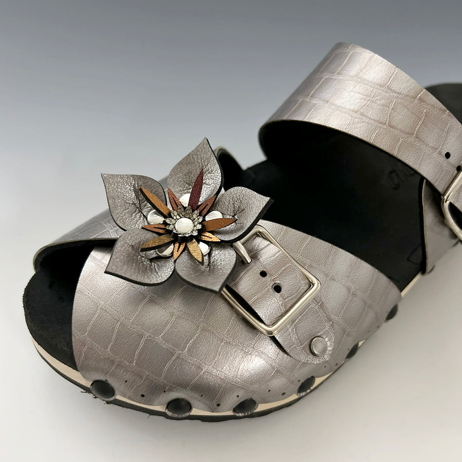 Shoe clips with silver faux leather flowers shown on a silver clog