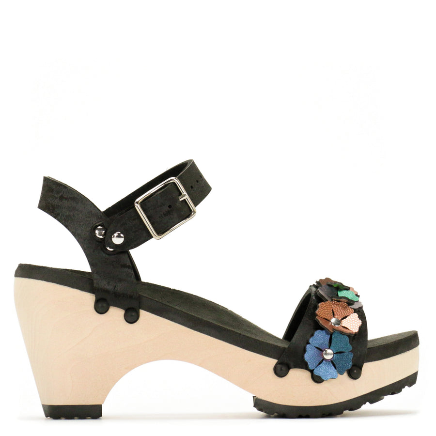 Side view of a sandal with 7 flowers along the toe, shown with a black ankle strap