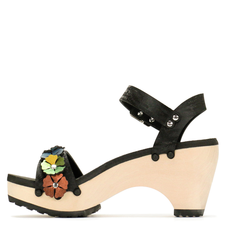Inside view of a sandal with 7 flowers along the toe, shown with a black ankle strap