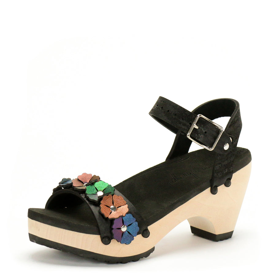 3/4 view of a sandal with 7 flowers along the toe, shown with a black ankle strap