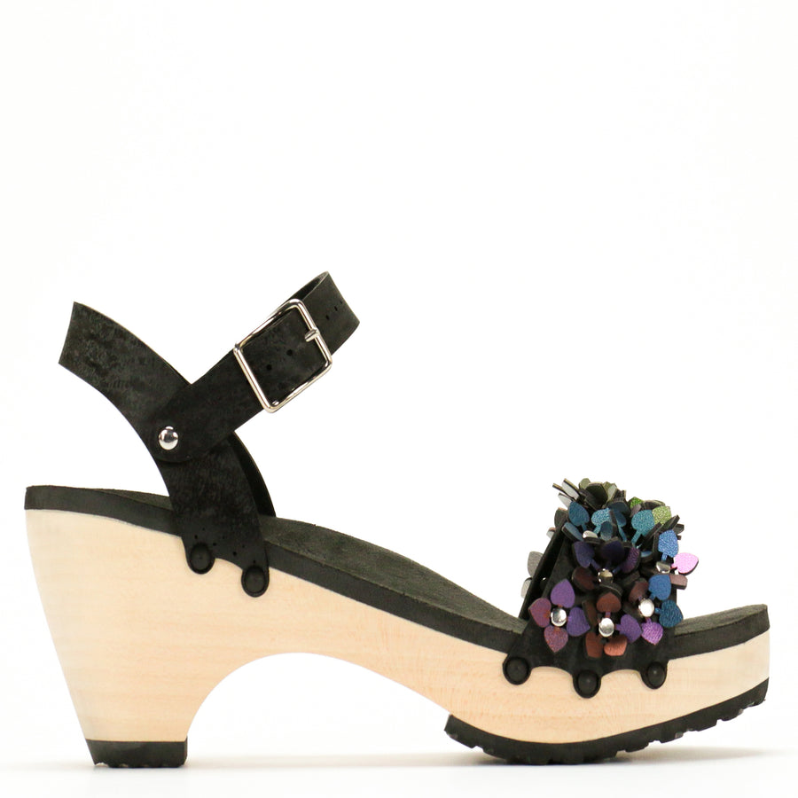 Side view of a sandal with a rainbow of glittery flowers on teh toes and an adjustable black ankle strap