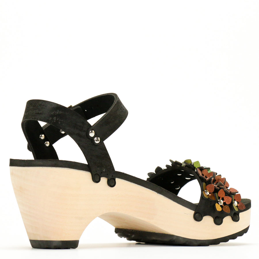 Back view of a sandal with a rainbow of glittery flowers on teh toes and an adjustable black ankle strap
