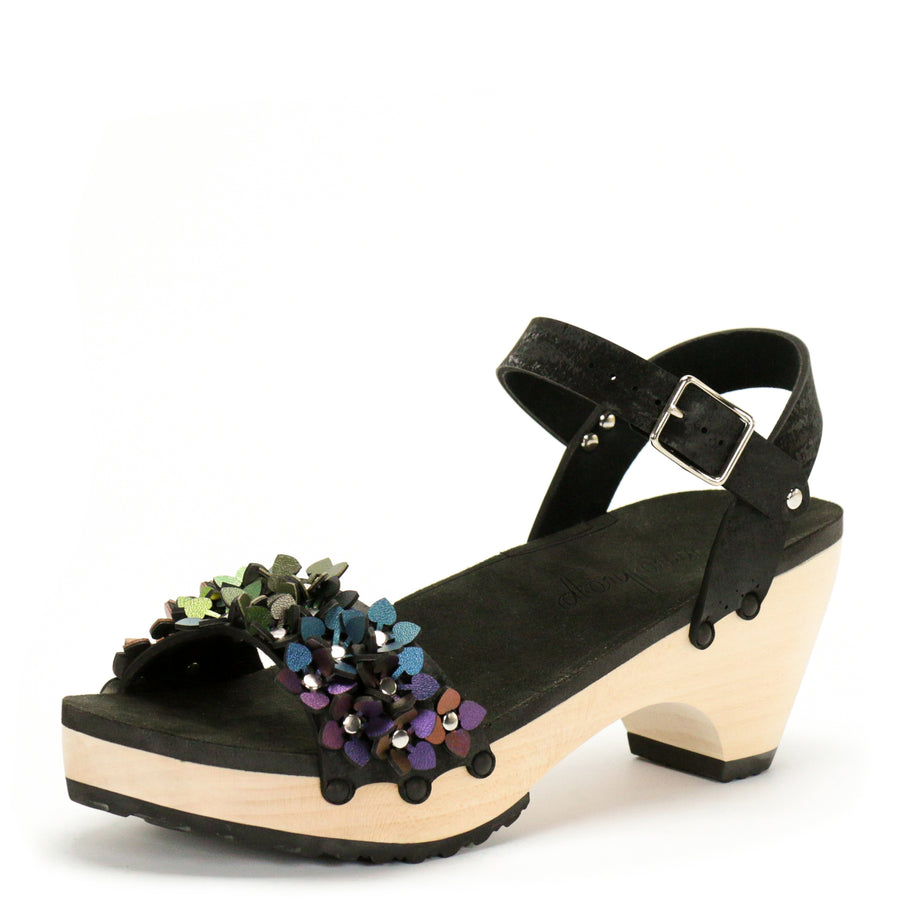 3/4 view of a sandal with a rainbow of glittery flowers on teh toes and an adjustable black ankle strap