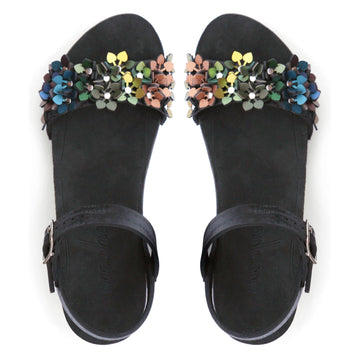 Top view of a sandal with a rainbow of glittery flowers on teh toes and an adjustable black ankle strap