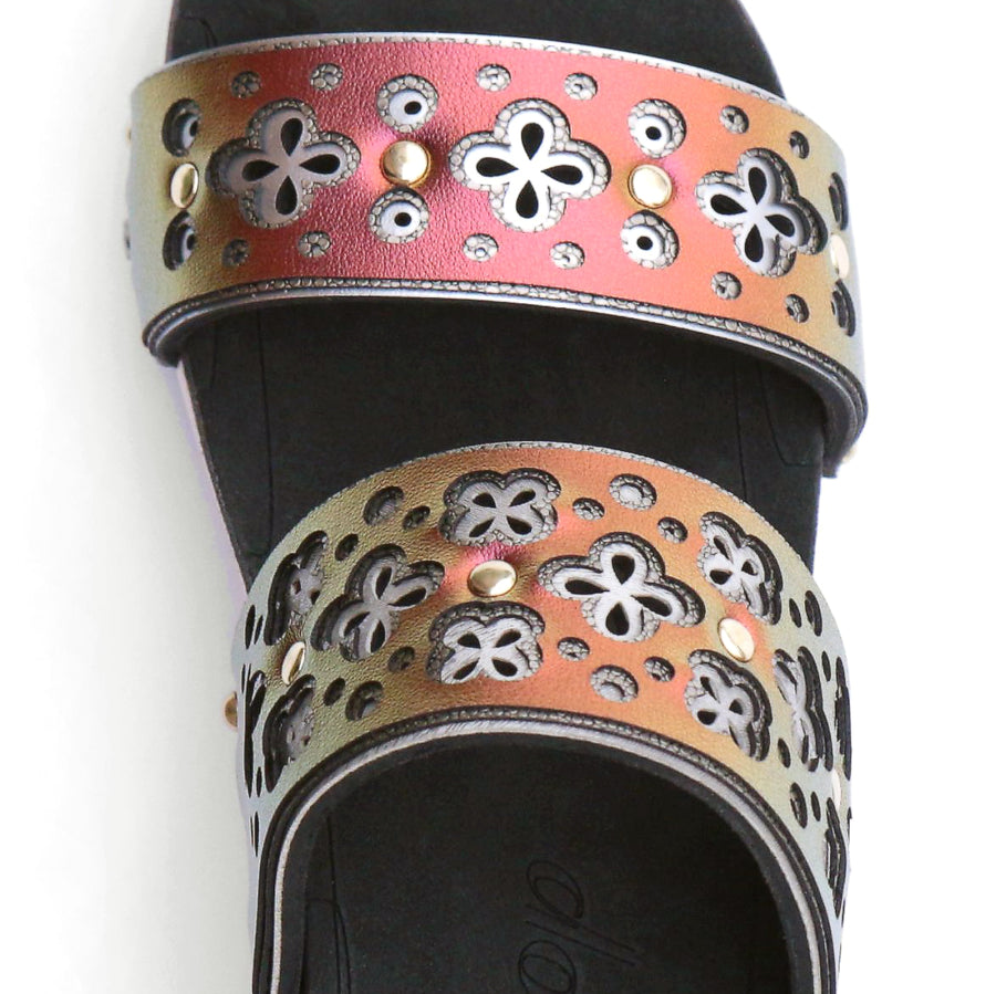 Detail view of a sandal with a laser cut layered upper in ruby