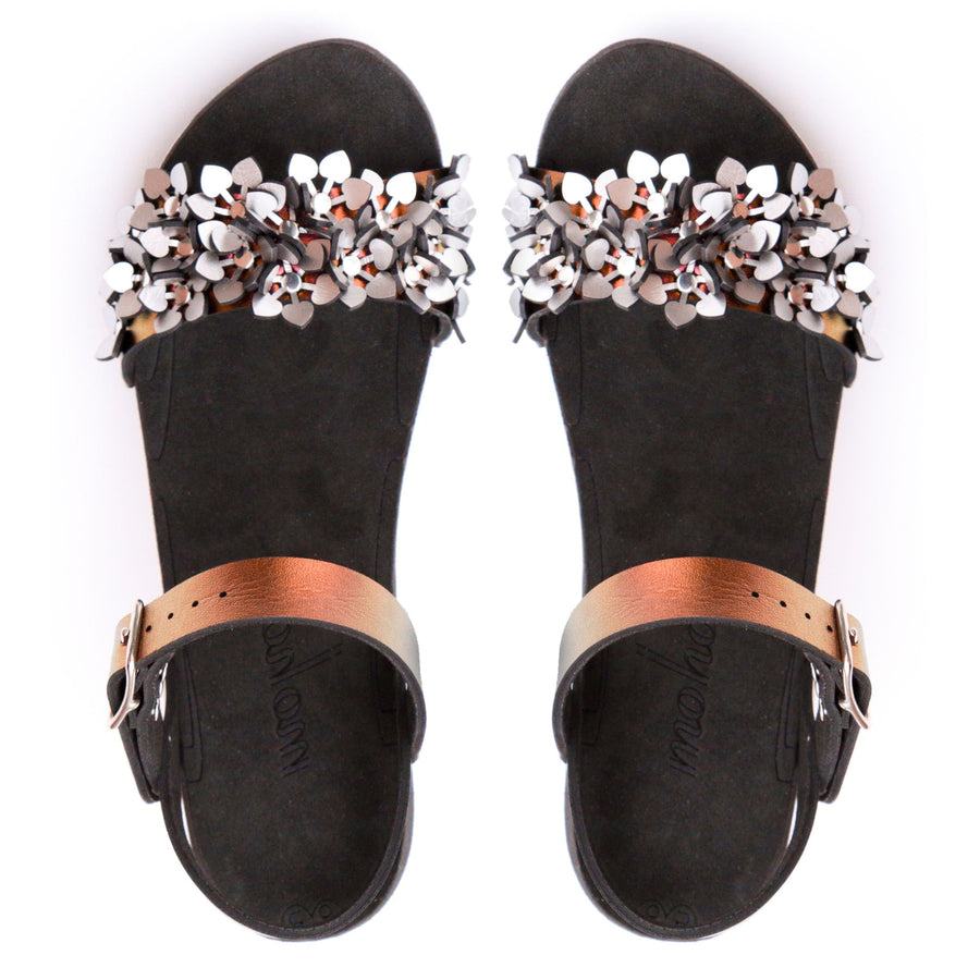 Top view of a sandal with a silver sparkly toe and red adjustable ankle strap