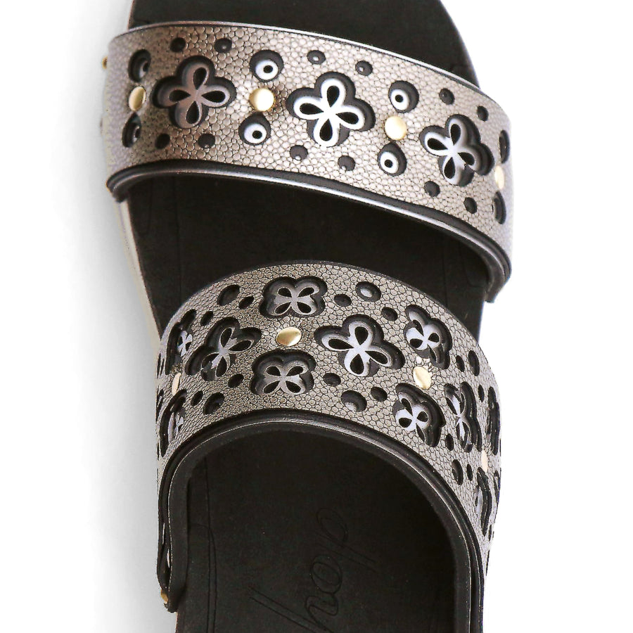 Detail view of a sandal with a gold and silver laser cut upper