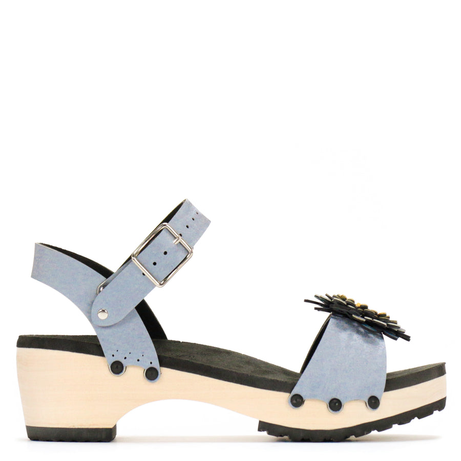 Side view of a sandal in arctic with an abstract floral pompom at the toe