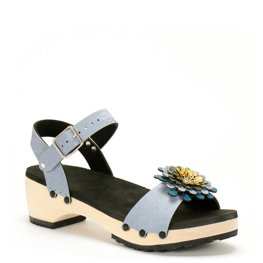 3/4 view of a sandal in arctic with an abstract floral pompom at the toe