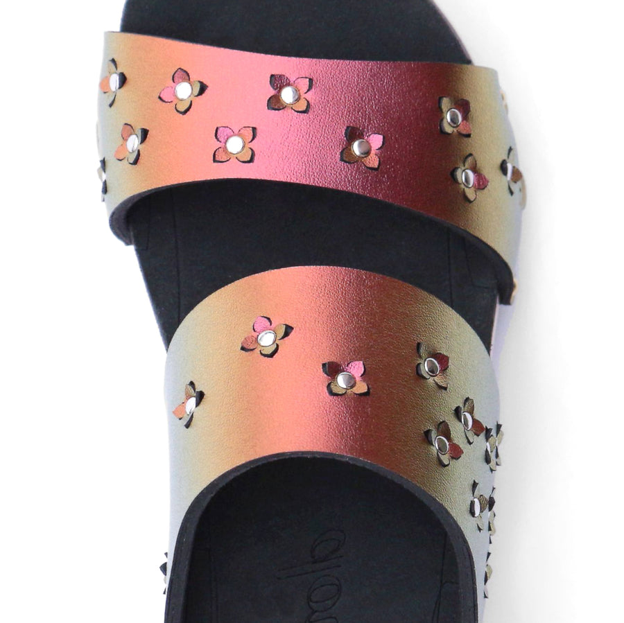 Detail view of sandals in iridescent red with tiny laser cut flowers sprinkled on the upper