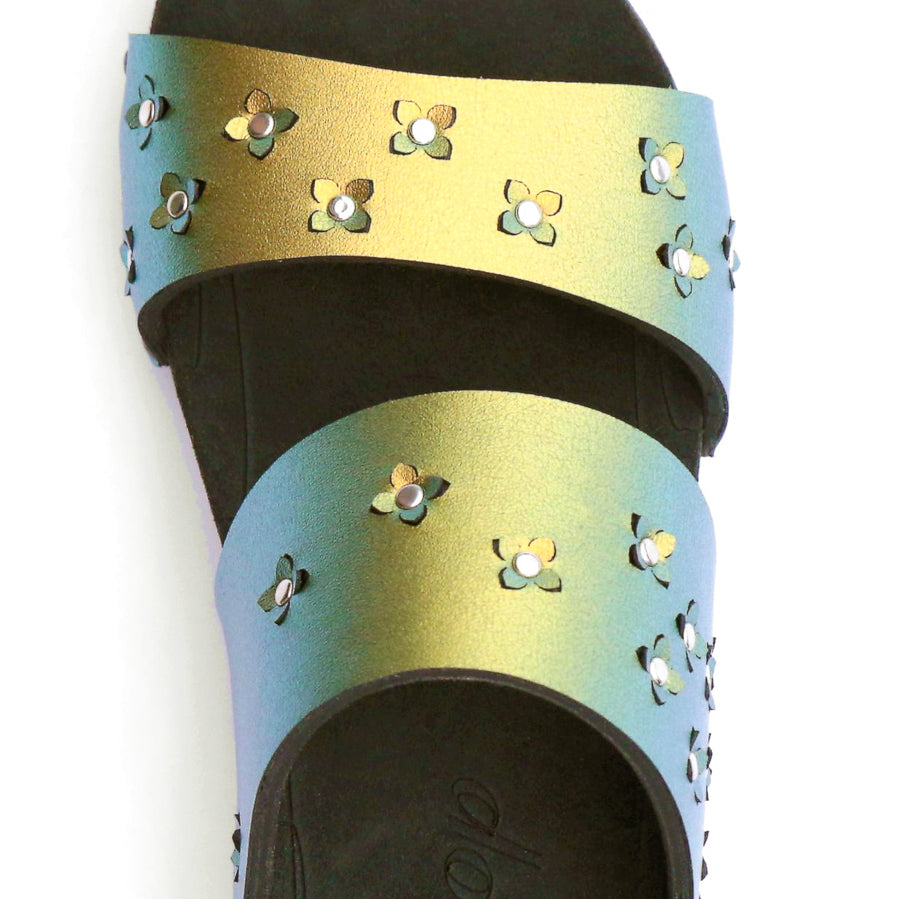 Detail view of sandals in iridescent gold with tiny laser cut flowers sprinkled on the upper