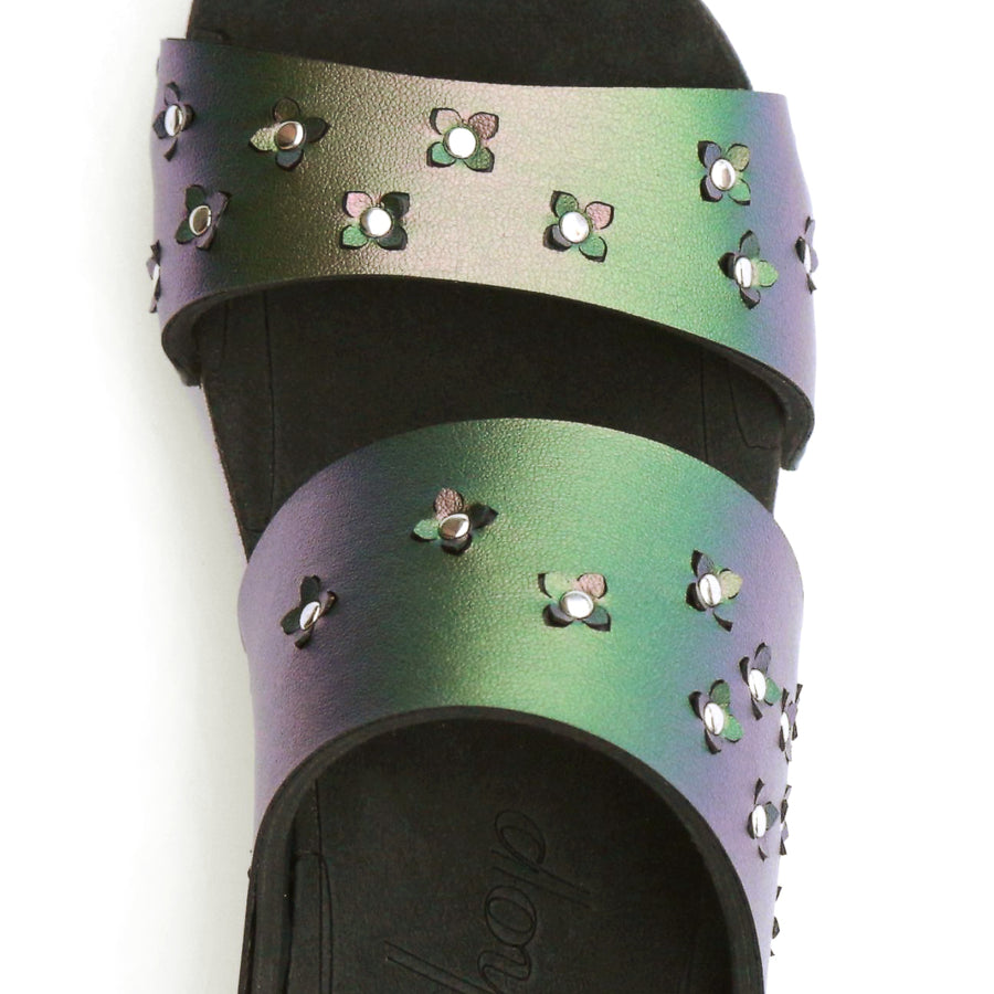 Detail view of sandals in iridescent green with tiny laser cut flowers sprinkled on the upper