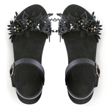 Top view of a sandal with laser cut flowers in matte black