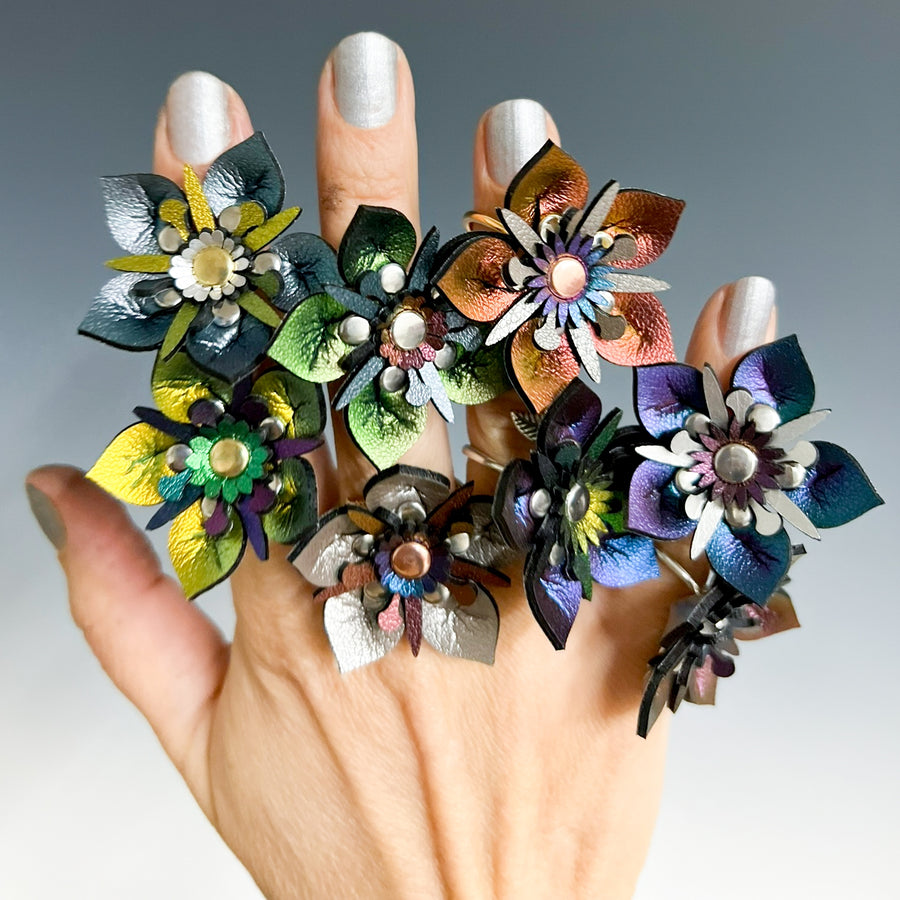 And assortment of 3D laser cut flower rings in a variety of iridescent vegan leathers