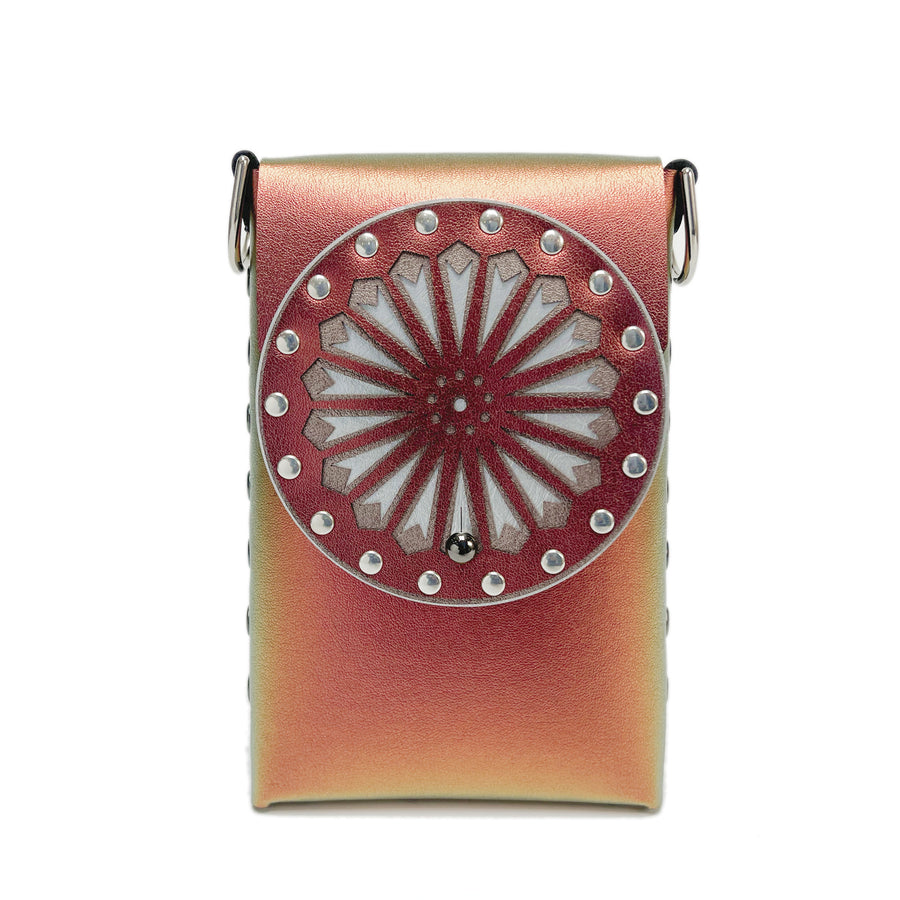 A small bag in red iridescent faux leather with a laser cut front flap
