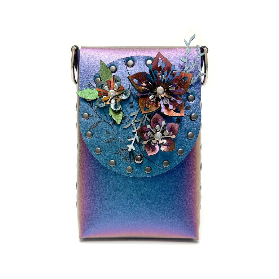 A small bag in blue iridescent vegan leather with a 3D floral laser cut front flap 