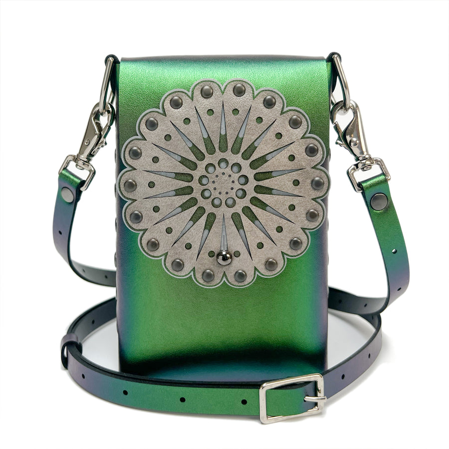 A small bag in green iridescent vegan leather with a laser cut front flap and adjustable crossbody strap