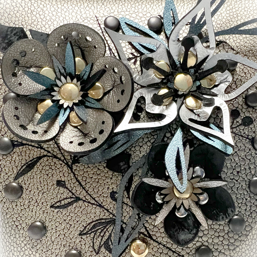 Floral detail shot of a small bag in gold shagreen vegan leather
